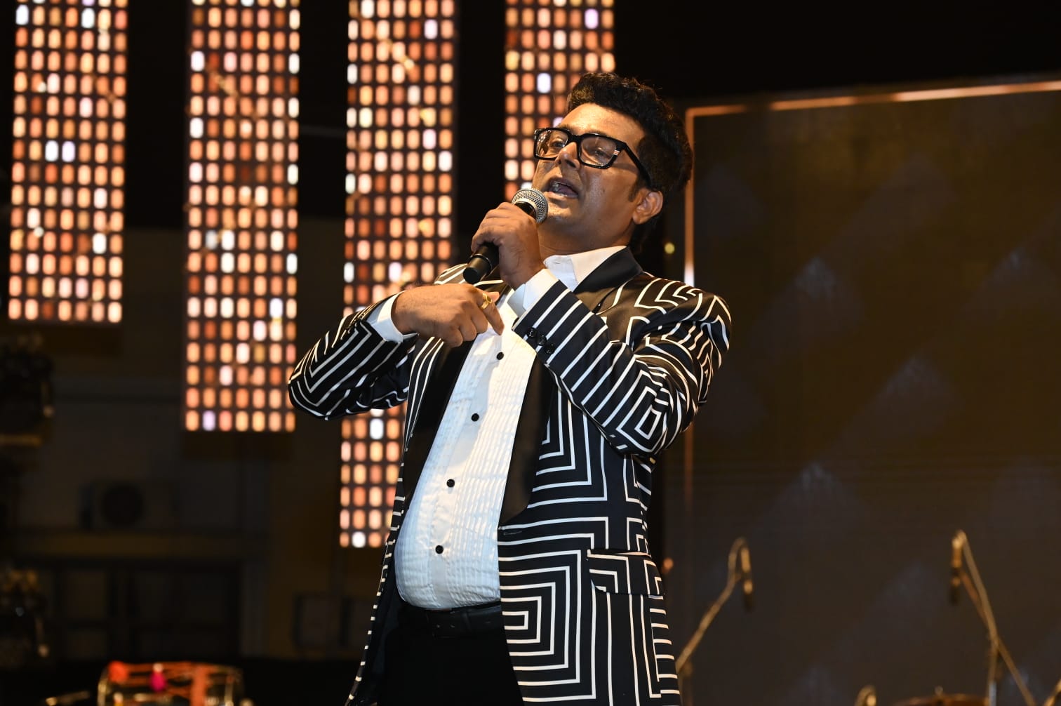 Navin Prabhakar anchoring a corporate event on stage